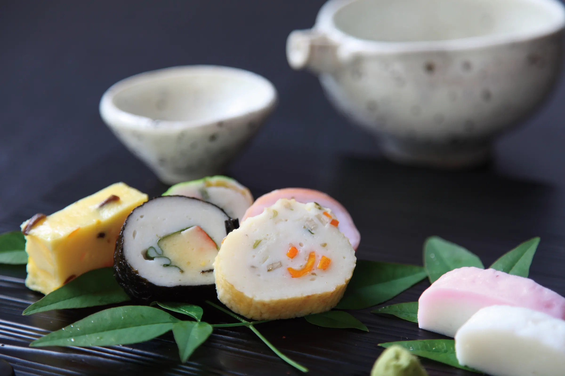 笹を敷いて盛りつけた料理蒲鉾と酒器